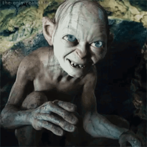 Gollum From The Lord Of The Rings Is Smiling And Looking At The Camera While Sitting On A Rock . GIF