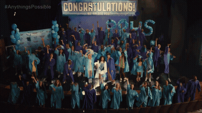 Graduates Standing In Front Of Congratulations Banner GIF