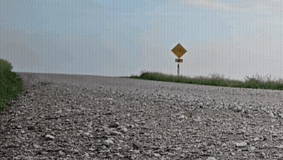 Gravel Road With Yellow No Trucks Sign GIF