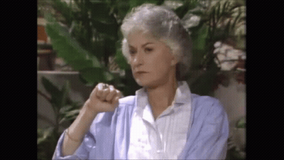 Gray-Haired Woman In Blue Cardigan Giving Thumbs Down GIF