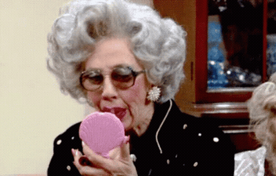 Gray-Haired Woman Looking In Pink Mirror GIF