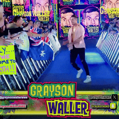 Grayson Waller Is Walking Down A Blue Carpet In Front Of A Crowd Of People GIF