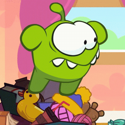Green Cartoon Character Sitting On Toys GIF