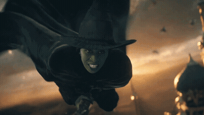 Green-Faced Witch In Black Hat Smiling GIF