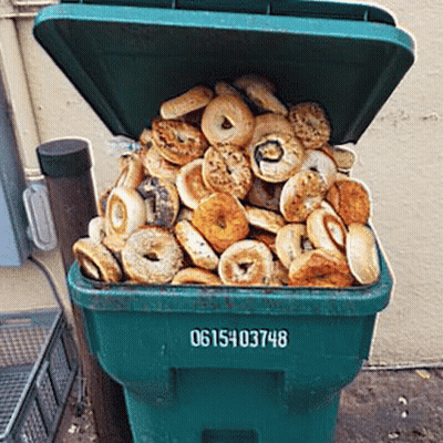 Green Garbage Can Filled With Bagels And Donuts GIF