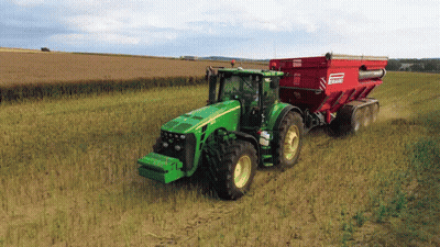 Green John Deere Tractor Pulling Red Bagger GIF