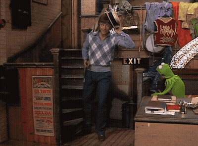 Green Kermit the Frog Standing in Front of Exit Sign