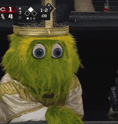 Green Mascot In Crown Sitting In Front Of Scoreboard Saying 1-2 GIF
