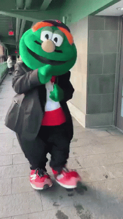 Green Mascot In Suit And Red Shoes GIF