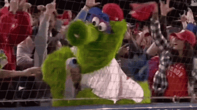 Green Mascot Standing In Front Of Crowd GIF