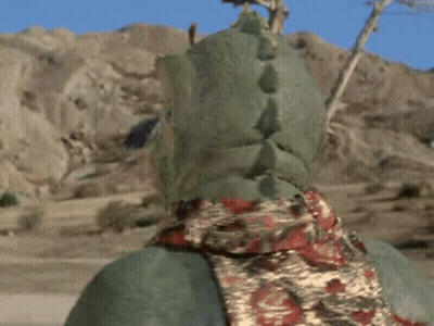 Green Monster With Horns And Scarf In Desert GIF