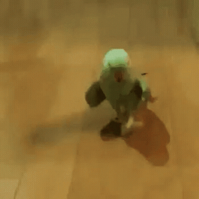 Green Parrot With Red Beak Walking On Wooden Floor GIF
