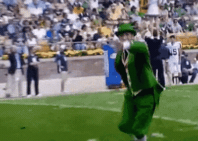 Green Suit, Hat Man Jumping On Football Field GIF
