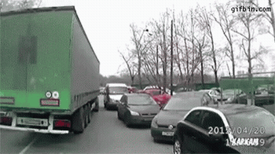 Green Truck Driving Through Parking Lot GIF