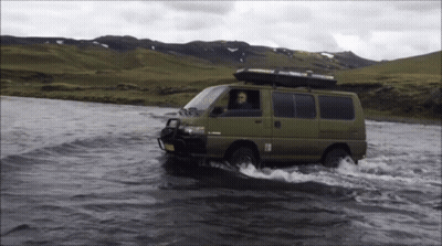 Green Van Driving Through River With Thule Roof Rack GIF