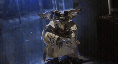Gremlin In Trench Coat In Dark Hallway GIF