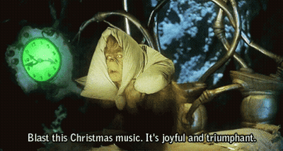 Grinch Says Blast This Christmas Music Joyful And Triumphant In Front Of Clock GIF