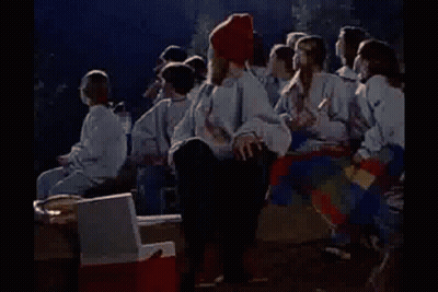 Group Around Campfire Woman On Cooler GIF