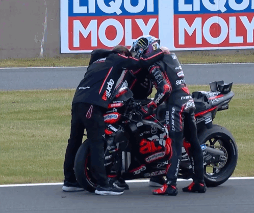 Group Around Motorcycle Saying Aprilia