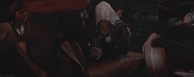 Group Around Table In Dark Room, One Hooded GIF