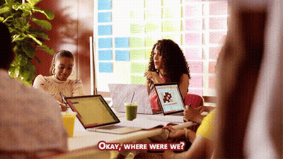 Group Around Table With Laptops Asking Where Were We GIF