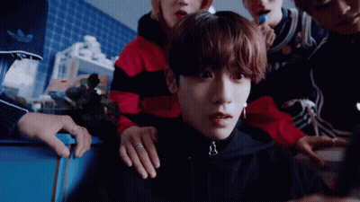 Group Around Young Man In Black Jacket GIF