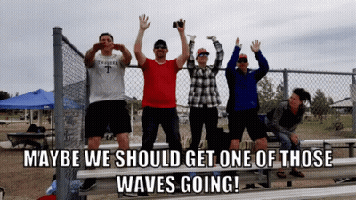 Group Behind Chain Link Fence Saying Maybe We Should Get One Of Those Waves Going GIF