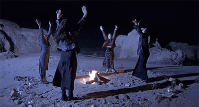 Group Dancing Around Fire On Beach At Night GIF