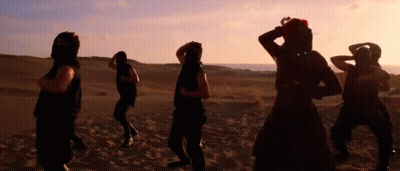 Group Dancing In Desert At Sunset GIF