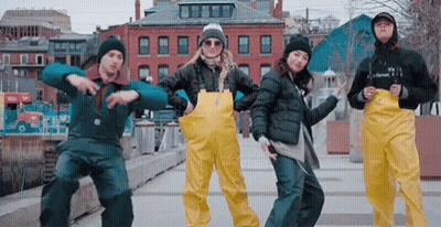 Group Dancing in Front of Building With Sign