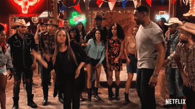 Group Dancing in Front of Cowboys Sign