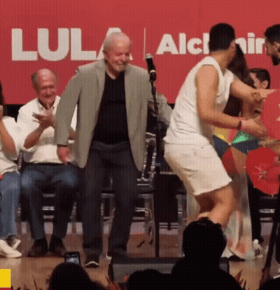 Group Dancing In Front Of Red Lula Sign GIF