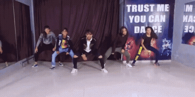 Group Dancing in Front of Trust Me You Can Dance Sign