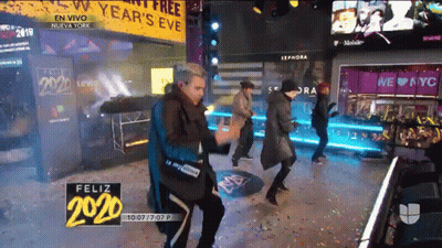 Group Dancing In Front Of Year's Eve Sign GIF