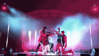 Group Dancing On Stage In Pink And Blue Lights GIF