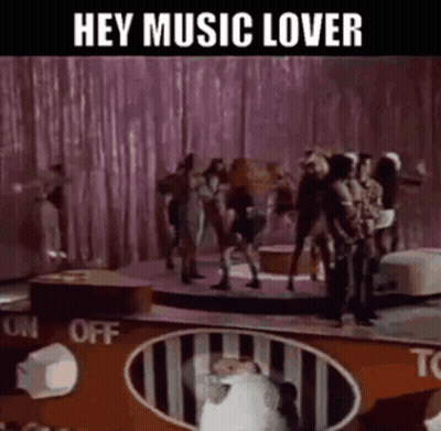 Group Dancing On Stage With Hey Music Lover Sign GIF