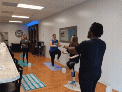 Group Doing Yoga Under Wall Clock GIF