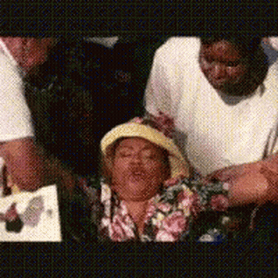 Group Gathered Around Woman In Hat GIF