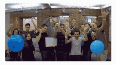 Group Holding Blue Balloons And Whiteboard GIF