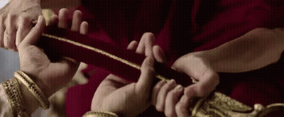 Group Holding Red Cloth With Gold Trim GIF