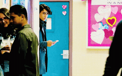 Group In Front Of Bulletin Board Saying In A New GIF