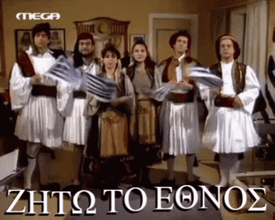 Group In Greek Costumes Holding Flags In Front Of Mega Logo GIF