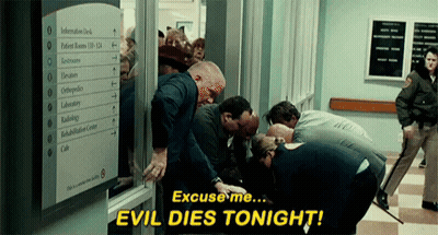 Group In Hallway With Sign Saying Evil Dies Tonight GIF