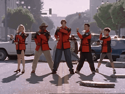 Group In Red Jackets On Street Corner GIF