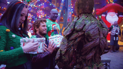 Group In Ugly Sweaters Holding Gifts GIF