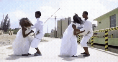 Group In White Clothes Standing On Sidewalk GIF