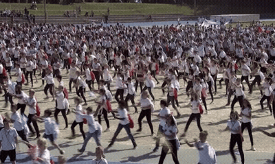 Group In White Shirts Dancing In Field GIF