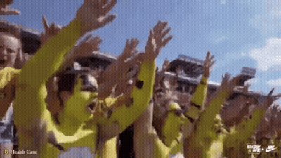 Group In Yellow Shirts Raising Hands GIF