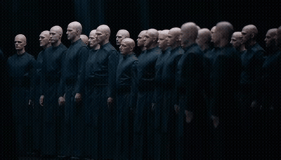Group Of Bald Men In Black Uniforms Standing In Line GIF
