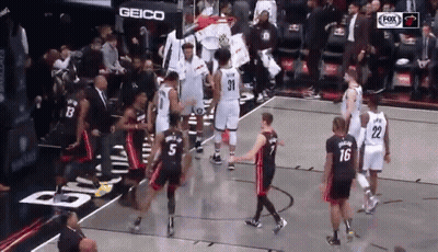 Group Of Basketball Players On Court With Geico Sign GIF